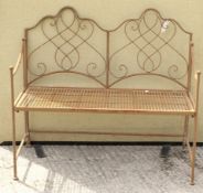 A vintage metal framed garden bench. Having a mesh seat and a scrolling backrest.