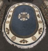 A Tabris Super Jordanian oval blue and cream rug. Borders including 'Greek Key' pattern.