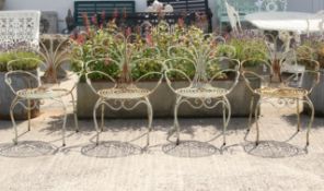 Four vintage metal framed chairs. Having decorative scrolling backs.