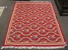 A contemporary red ground geometric cotton rug.