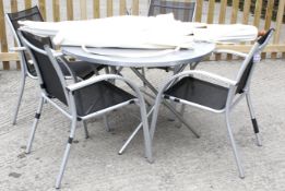 A contemporary circular garden table, a set of four chairs and a parasol.