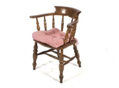 A 'Smokers Bow' open armchair. With turned spindles and supports having a central double stretcher.