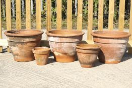 Five terracotta garden pots. Including a set of three pots with ribbed decoration, max H38cm.
