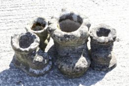 A large weathered stone pot in the form of an old boot and three others. The largest approx.