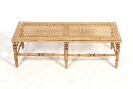 A rattan top coffee table. With turned tapering supports united by stretchers.