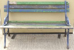 A slat-back garden bench. With cast iron open scroll end supports and legs.