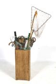Walking sticks, fishing nets and shooting sticks in a lidded wooden stand.