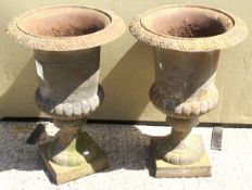 A pair of cast metal garden urns. Having embossed decoration, mounted on square bases.