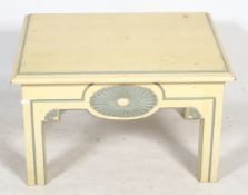 A contemporary cream painted coffee table with grey painted details. With square supports.