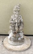 A weathered reconstituted stone figure of a jolly gnome.