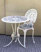 A round white-painted garden table and a chair with an anthemion back