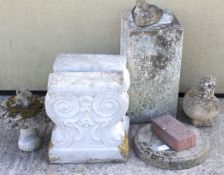 An assortment of garden items including a pair of cast concrete bench ends.