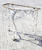 A wrought iron shaped semi-circular garden table.