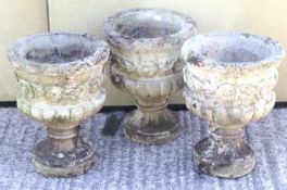 A set of three reconstituted stone stone garden urns.