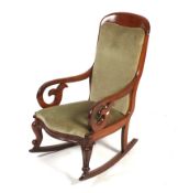 A 19th century mahogany framed rocking chair. With green velvet upholstery, carved scroll arms.