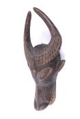 An African tribal carved wooden buffalo head. With a hollow mouth, bearing its teeth.