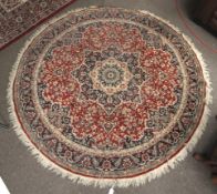 A Persain style circular wool rug. Having a red and blue ground, multiple geometrical borders.