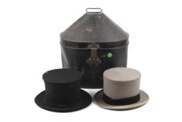An antique tin hat box and two top hats.