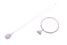 A vintage 'designer' silver bangle and a locket and chain. The 3.