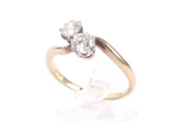 A mid-early 20th century diamond two stone cross over ring. The early round brilliants approx. 0.