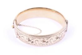 A vintage gold-plated part foliate engraved broad hinged bangle. Stamped '1/5 9ct metal core', 15.