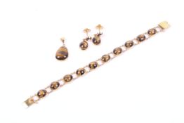 A Middle Eastern tiger eye bracelet, pendant and earring set.