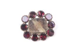 An early 19th century rose gold and flat-cut garnet memorial cluster brooch, circa 1820.