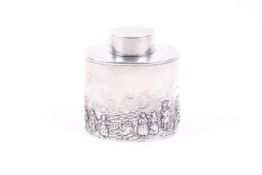 A silver oval tea caddy embossed with figures in a pastoral landscape.