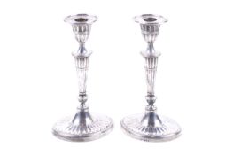 A pair of Edwardian silver oval candlesticks.