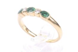 A modern 18ct gold, emerald and diamond five stone ring.