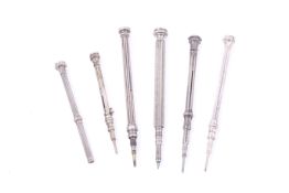 A group of six Victorian and later white metal propelling pencils.