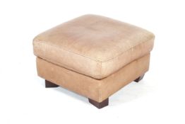 A brown leather footstool.