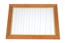 A maple framed rectangular wall mirror.