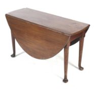 A 20th century mahogany drop leaf table. Of oval form, the shaped supports ending in bun feet, H69.