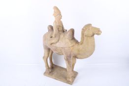 A large Chinese Tang Dynasty earthenware camel and rider.