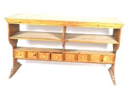 A large pine kitchen island work bench. Open storage and a bank of drawers beneath.