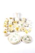 A collection of Belleek ceramics. Including jugs, lidded pots, a fluted vase, teacup trio and more.