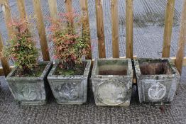 A group of four concrete garden planters.
