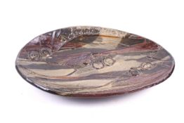 A Studio Art pottery oval slab three-footed dish. Impressed abstract decoration.