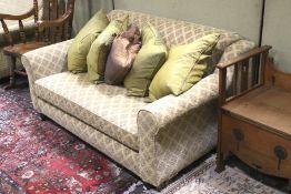 A re-upholstered 20th century two seater sofa. With turned wooden feet at the front.