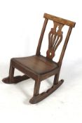 An antique farmhouse elm and oak rocking chair.