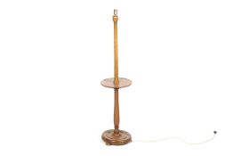 A 20th century walnut standard lamp. Having a wine table, mounted on a circular base with feet.