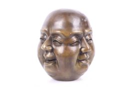 A large bronze four-faced Buddha head. Depicting four emotions, with a four character mark to base.