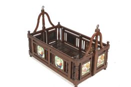 An Indian hardwood babies swing cradle. Decorated with ceramic tiles.