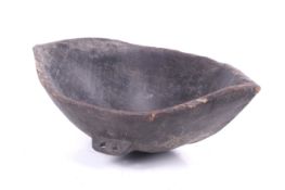 Papua New Guinea. A thickly carved wood bowl. With a lug to one long side pierced with two holes.