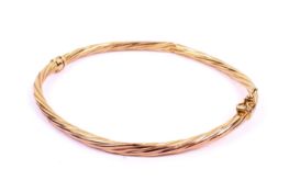 A 9ct gold hinged bangle. Of twist form, with a safety latch, 3.
