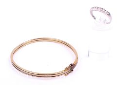 A white gold diamond set ring and a yellow metal bangle.