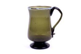 A 18th century Nailsea green glass tankard. With blue glass decoration to the rim, applied handle.