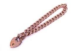 A rose coloured metal curb link bracelet. With padlock and safety chain fittings. Marked '9ct'.