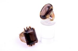 Two stone set yellow metal rings. Each set with semi precious material assessed as brown quartz.